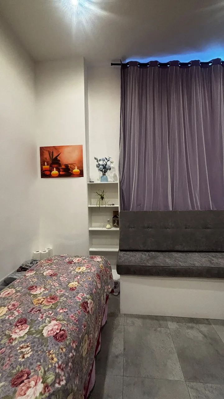 Treatment table beside the seating area and purple curtains
